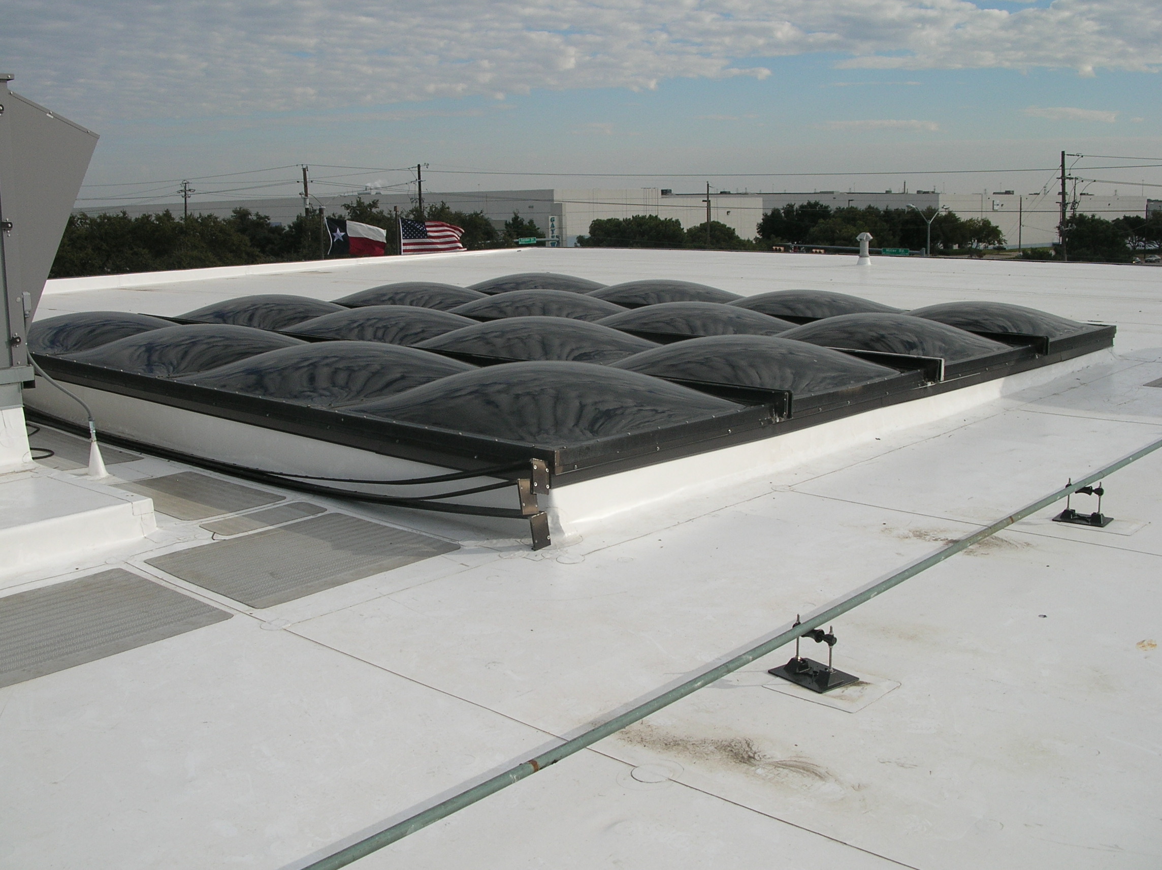 Skylight system with acrylic domes and aluminum framing.