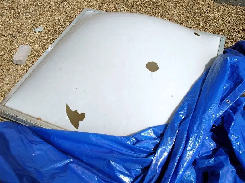 an acrylic skylight lens with holes in it due to hailstone strikes